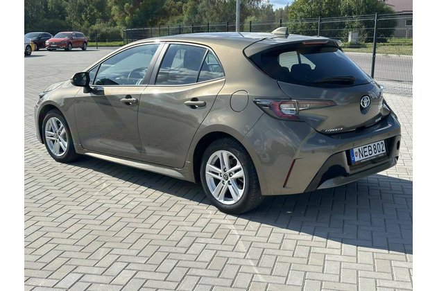 Side view of white Toyota Corolla available for rent